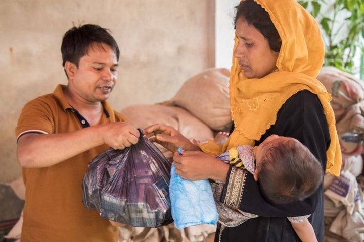 <p>A mother receives biscuits for her family at Kutupalong registered camp in Cox’s Bazar. </p>