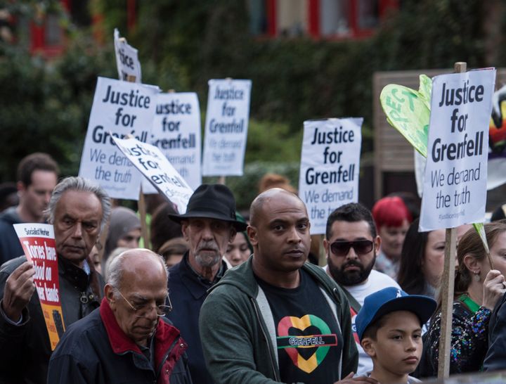 People take part in a silent march for Grenfell Tower fire victims in west London.