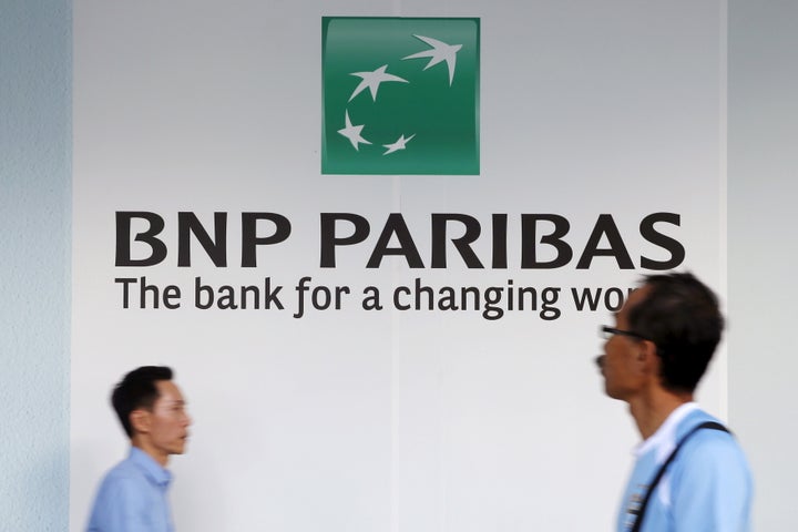 People pass a BNP Paribas bank logo in Singapore's central business district in a photo shot in January 2016.