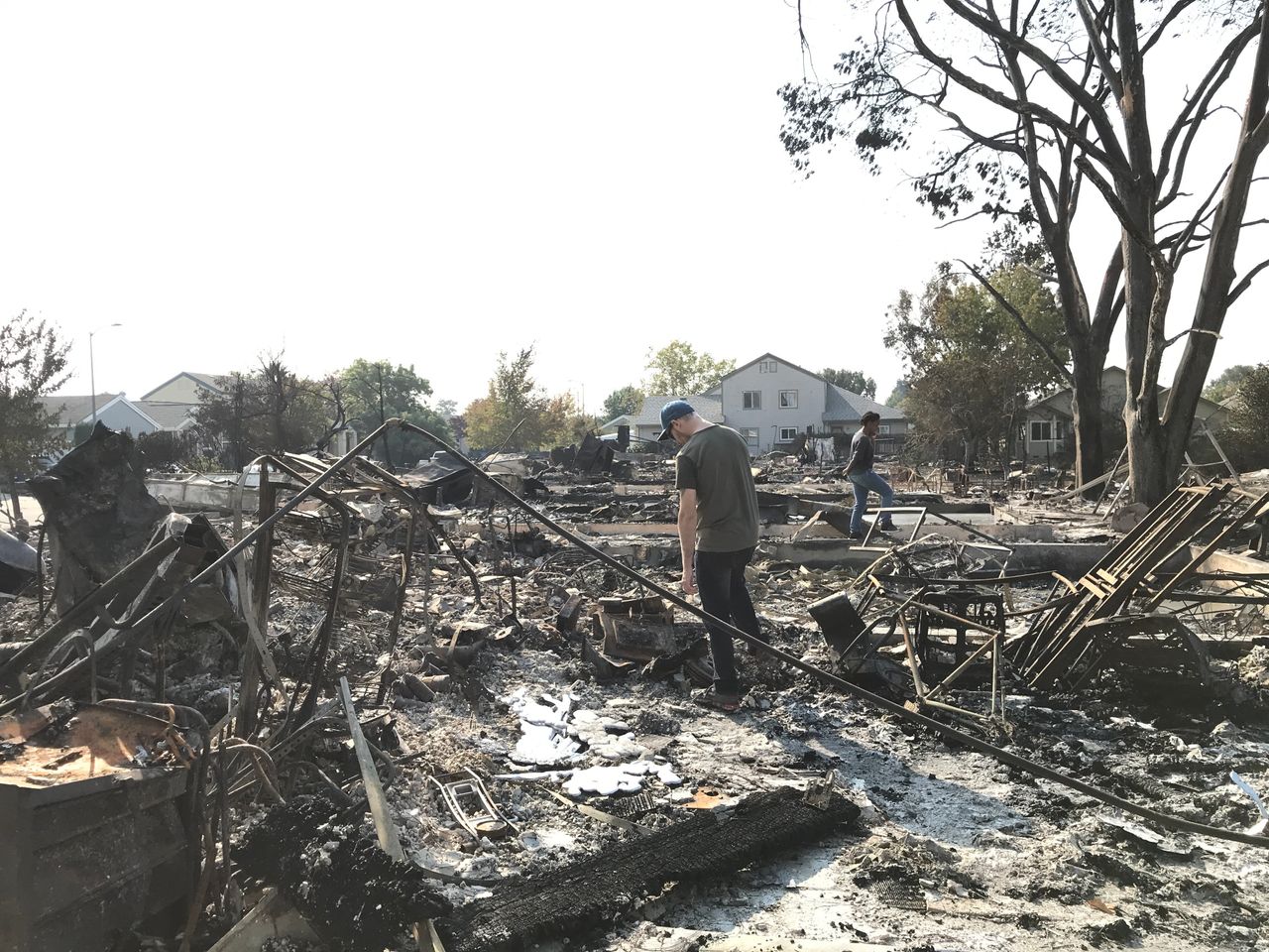 Maryanne Rahab (right) walks through the rubble of the house she had been renting in Coffey Park for over a year with her boyfriend, Sean Parsons (left).