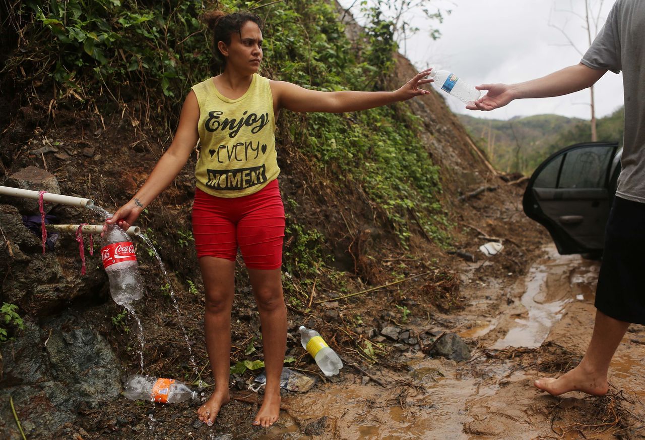 Puerto Rican resident Yanira Rios collects spring water nearly three weeks after Hurricane Maria destroyed her town of Utuado, which still has little running water or power.
