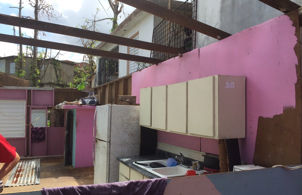 A home in Humacao without a roof. An elderly couple still lives here. There is no door. There is mold in the air. The couple sleeps on a mattress that got soaked during the hurricane and stays wet as rain continues to fall into the home.