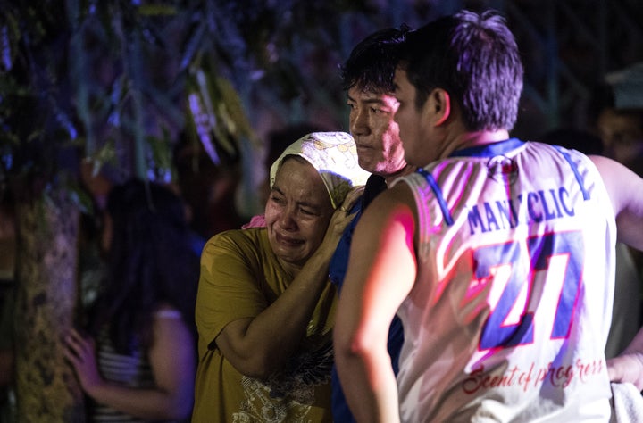 Relatives of Aldrin Castillo, an alleged drug user killed by unidentified assailants, grieve as they arrive at the crime scene in Manila on Oct. 3, 2017.