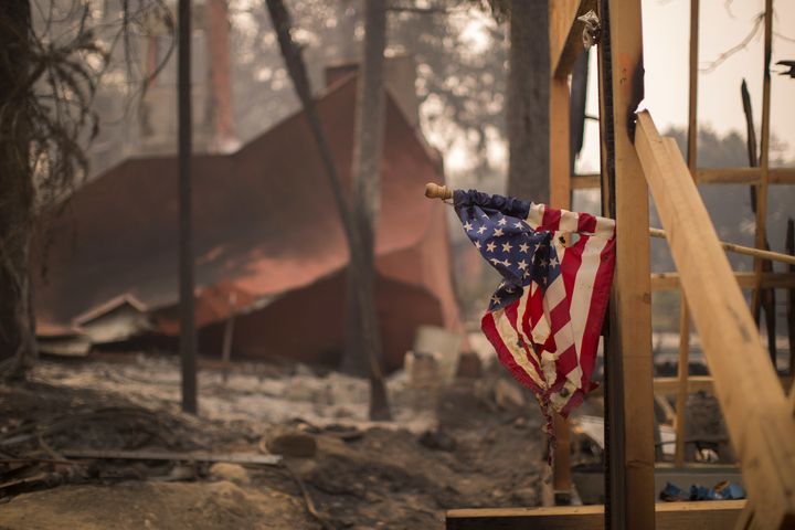 A partially melted American flag hangs in Soda Canyon at a construction site among houses that were destroyed on Oct. 11.