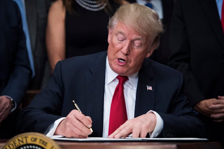 President Donald Trump signs an executive order on health care in the Roosevelt Room at the White House in Washington, DC on