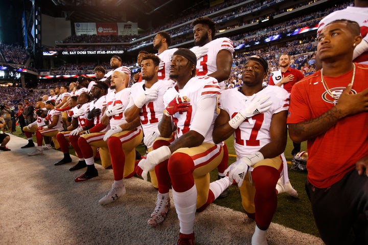 The San Francisco 49ers kneel and stand together while the national anthem plays prior to their game against the Indianapolis Colts on Oct. 8.