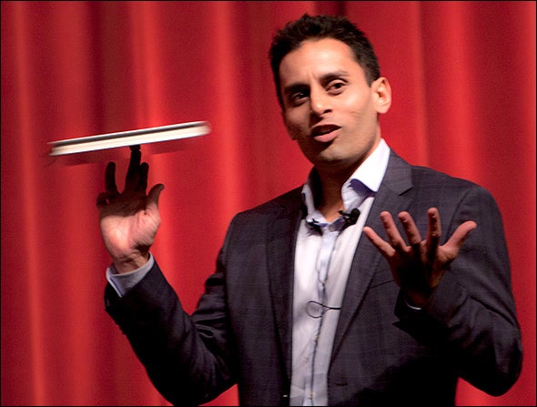 Dr. Sudip Bose spins his laptop on his finger as if it’s pizza dough while making a point at a recent speaking engagement.