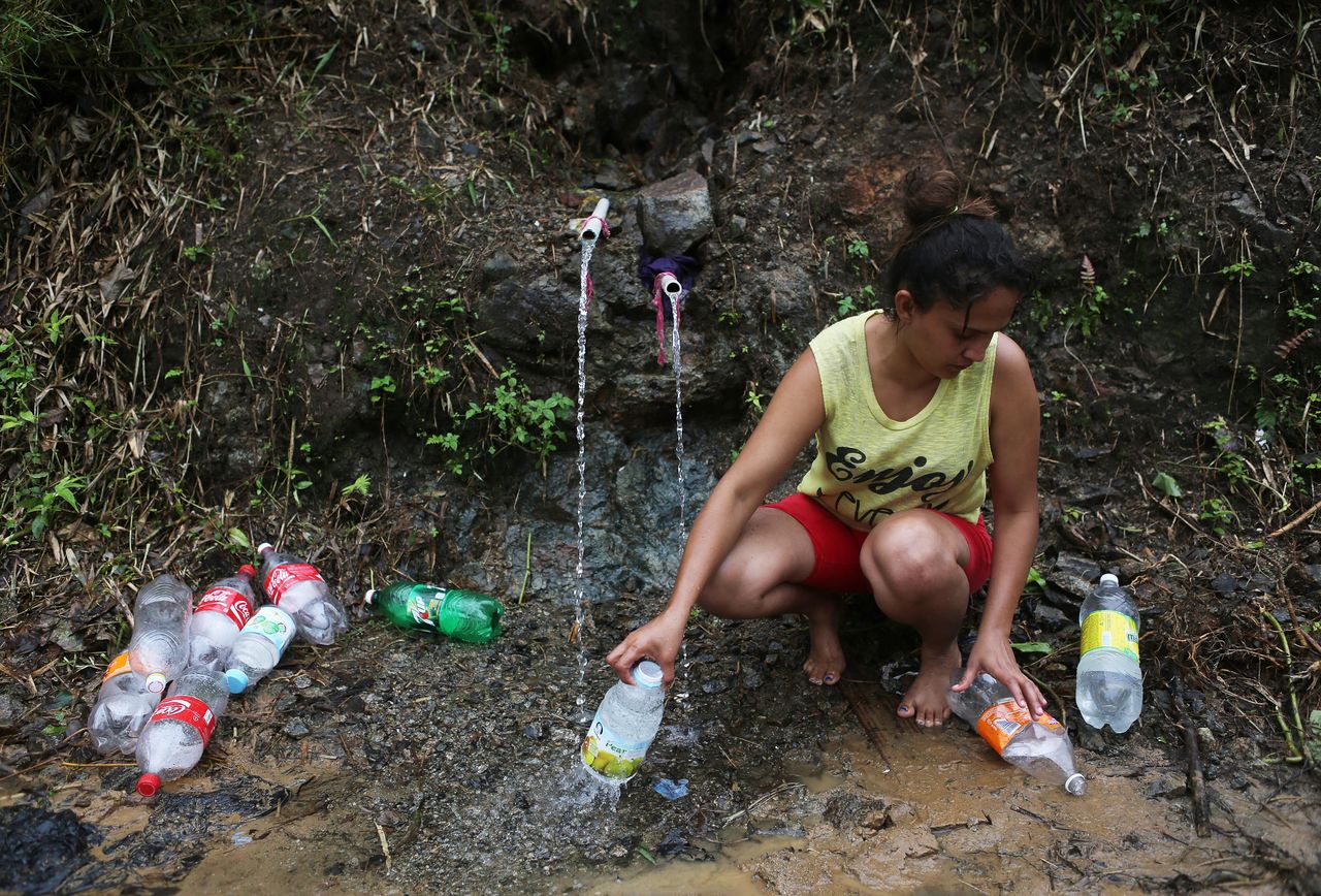 Yanira Rios recoge agua de un manantial para usarla en su casa en Utuado, Puerto Rico. La mayor parte del municipio sobrevive sin agua corriente ni electricidad desde que el huracán María llegara a la isla el 20 de septiembre.