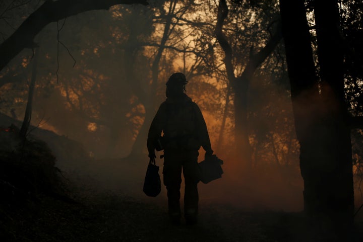 A firefighter brings supplies to crewmates, while working to control a wildfire in Sonoma, California, U.S., October 14, 2017