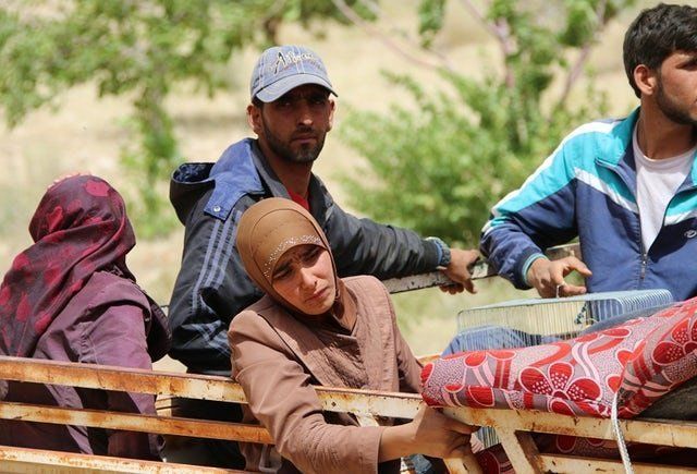 Syrian refugees are seen on the back of a pickup truck in the Lebanese eastern border town of Arsal as they head toward the Syrian region of Qalamoun on July 12, 2017.