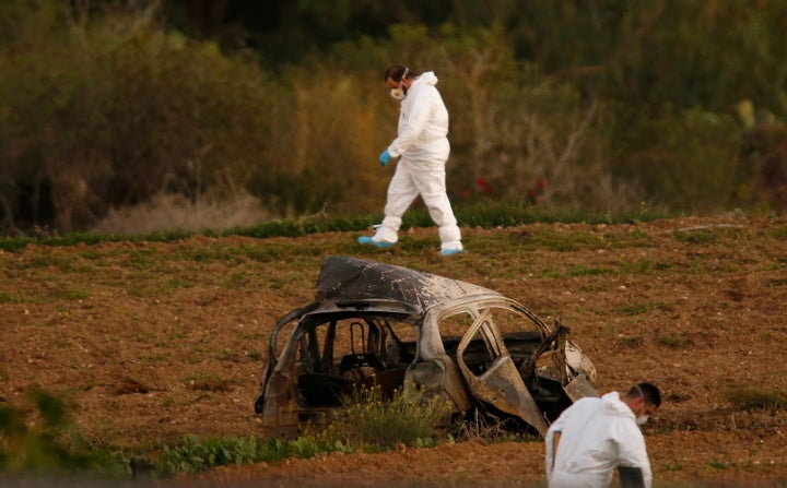 <strong>Forensic experts walk in a field after a powerful bomb blew up a car and killed investigative journalist Daphne Caruana Galizia in Bidnija, Malta.</strong>