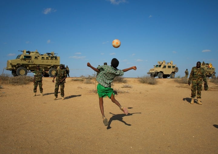 <p><em>Ugandan soldiers deployed with AMISOM play football with Somali children after taking back a town from al-Shabab. </em></p>