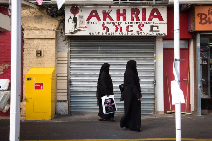 Two muslim women walk past an African clothes store in Shepherd's Bush market in west London. A surge in post-Brexit hate crimes has been confirmed in the latest Home Office figures