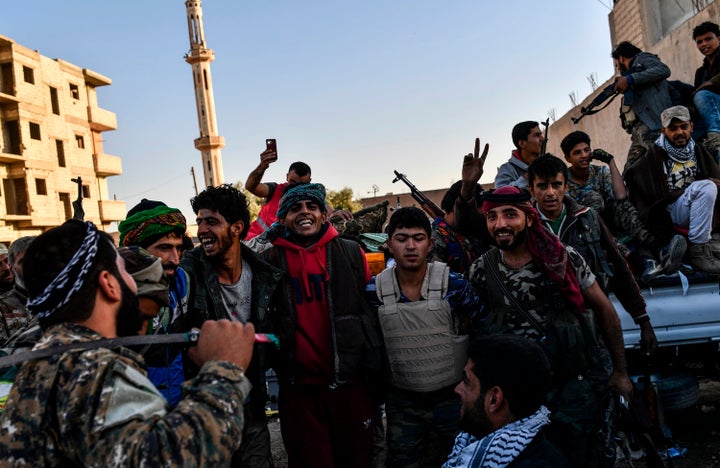 Members of the Syrian Democratic Forces (SDF), backed by US special forces, celebrate at the frontline in the Islamic State (IS) group jihadists crumbling stronghold of Raqa on October 16, 2017. US-backed fighters battled hundreds of Islamic State group jihadists holed up in the last pockets of Syria's Raqa, as the former extremist stronghold stood on the verge of capture. 