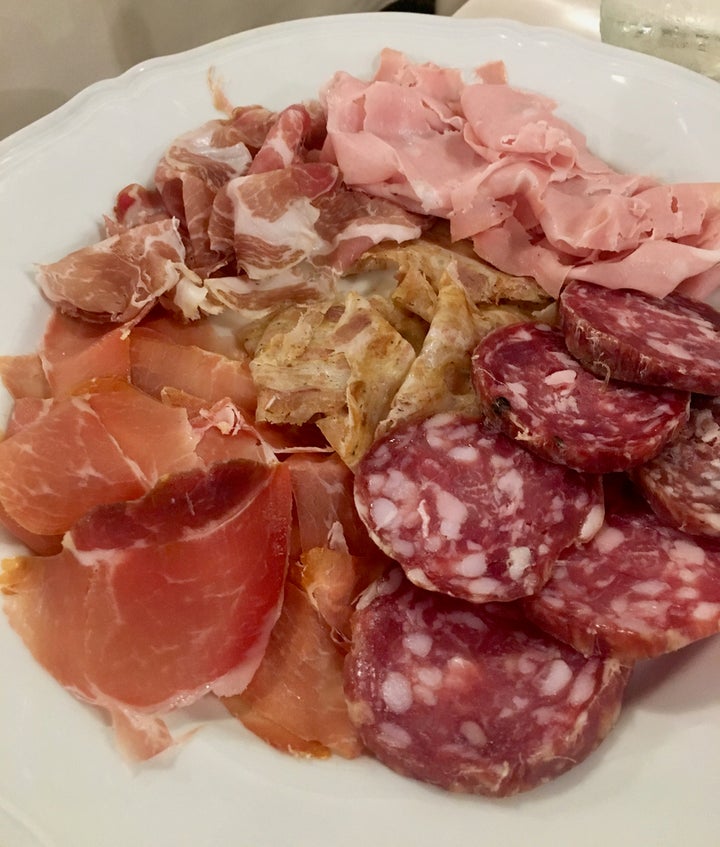 <p>Salumi at Trattoria Pomposa, Modena. The beige slices in the center of the platter are ciccioli</p>
