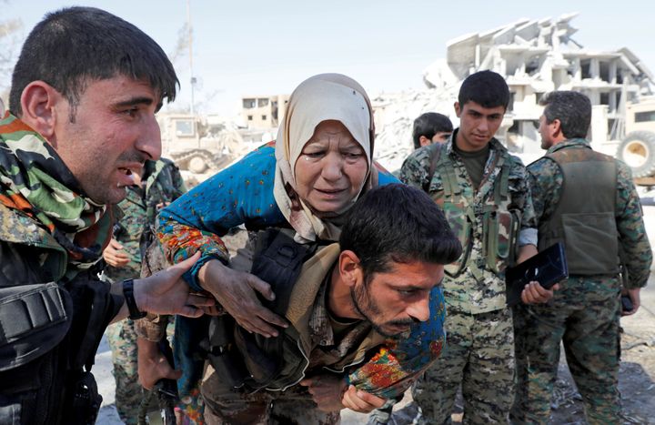 Fighters of Syrian Democratic Forces evacuate a civilian from the stadium after Raqqa was liberated from the Islamic State militants in Raqqa, Syria.