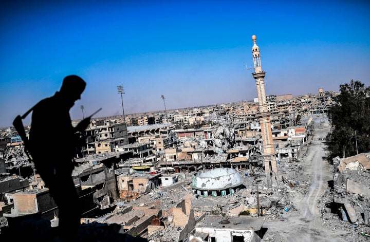 A member of the Syrian Democratic Forces, backed by U.S. Special Forces, talks on the radio near Raqqa's stadium as the SDF c