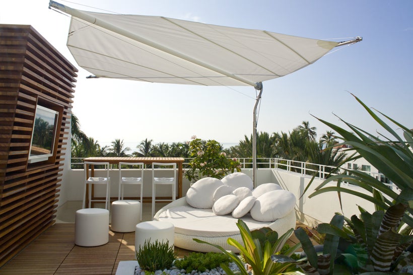 Luxe white daybeds scatter the roof next to the pool and overlook the ocean beyond. Brilliant way to watch the sun go down wi