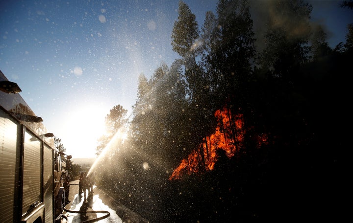 Firefighters work to put out the flames next to the village of Macao, near Castelo Branco, Portugal, on Aug. 17, 2017.