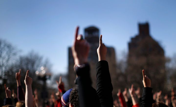 Women raise one finger to the air as part of a "One Billion Rising" rally in New York City's Washington Square Park, February 14, 2013.