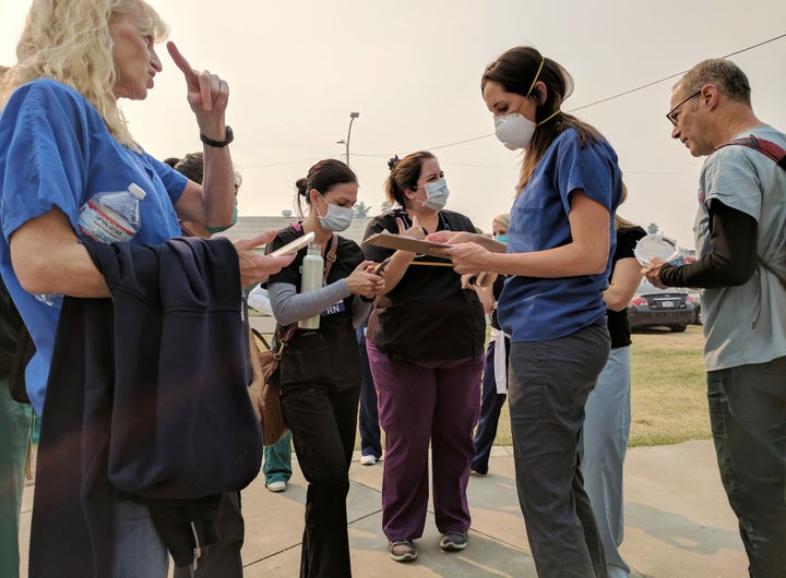 Las enfermeras voluntarias usan máscaras protectoras debido al humo de los incendios forestales que reciben cuando reciben instrucciones en un refugio en Petal