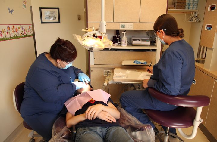 <p>Dental Therapists, Elsie Pelawook and Savannah Bonorden, performing dental work on a patient. </p>