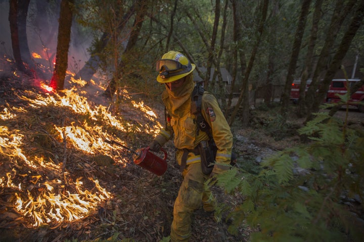 A firefighter uses a drip torch to set a backfire to protect houses in Adobe Canyon during the Nuns Fire on Oct. 15, 2017 near Santa Rosa, California.