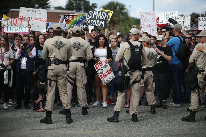 Protesters are held behind a line of police as they react to Spencer's speech