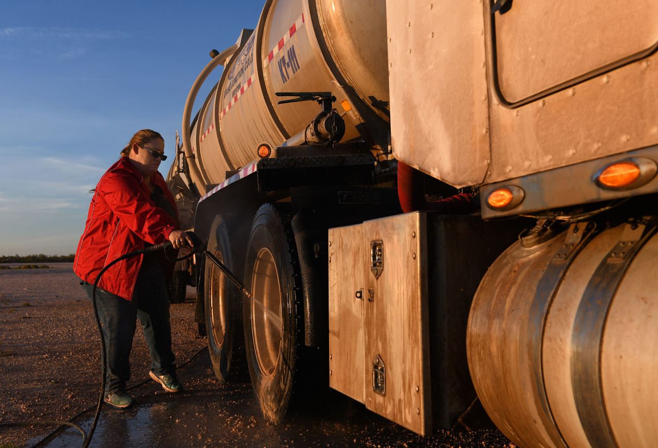Tara Smith washes an oil tank truck in a yard west of Odessa. 