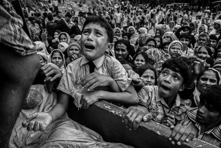 A Rohingya boy cries as he climbs on a truck distributing aid for a local NGO near the Balukali refugee camp on Sept. 20 in Cox's Bazar, Bangladesh.