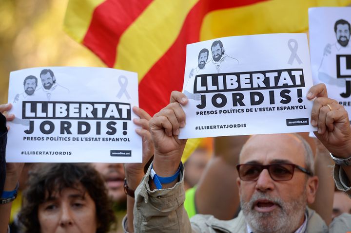 People hold placards reading 'Freedom for Jordis' during a demonstration on October 21, 2017 in Barcelona, to support two leaders of Catalan separatist groups, Jordi Sanchez and Jordi Cuixart, who have been detained pending an investigation into sedition charges