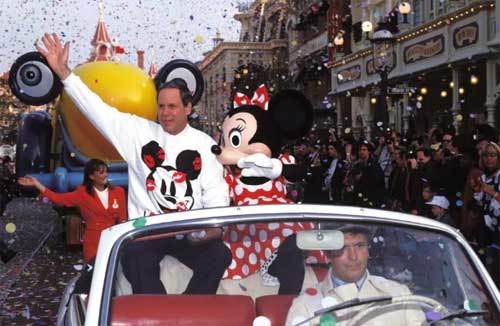 Michael Eisner rides along with Minnie Mouse in the opening day parade at Euro Disneyland Park. 