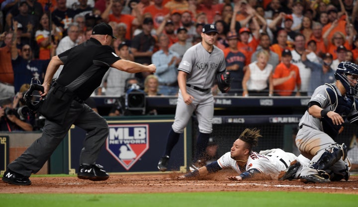 Yuli Gurriel #10 of the Houston Astros slides home to score on the two-RBI double hit by Brian McCann #16 in the fifth inning of game seven of the American League Championship Series against the New York Yankees at Minute Maid Park on Saturday, October 21, 2017 in Houston, Texas. (Photo by Cooper Neill/MLB Photos via Getty Images)