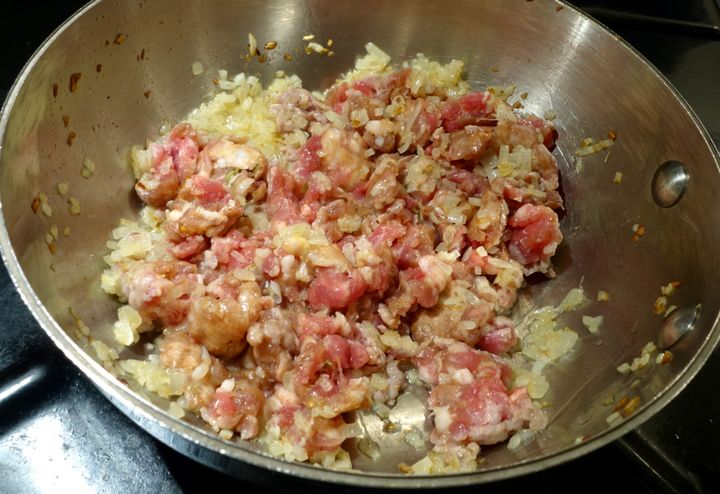 <p>Add the sausage meat and break it up with a spoon</p>