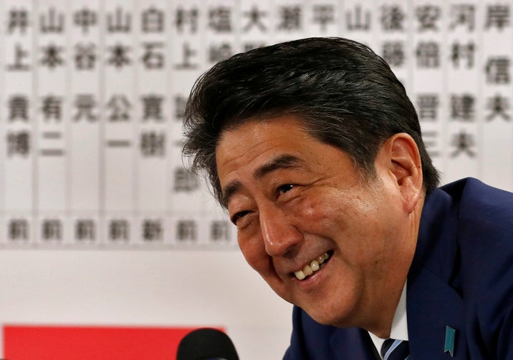 Japan's Prime Minister Shinzo Abe, leader of the Liberal Democratic Party (LDP), smiles during a news conference after Japan'