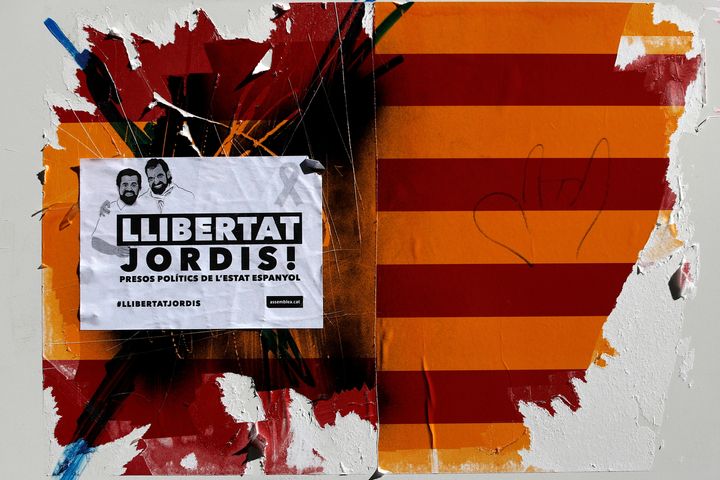 A damaged sticker of a Spanish and Catalan flag and a placard reading "Freedom to Jordis!".