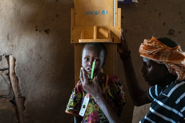 A community health worker examining a child’s nutrition status in Marsabit County in Kenya.  