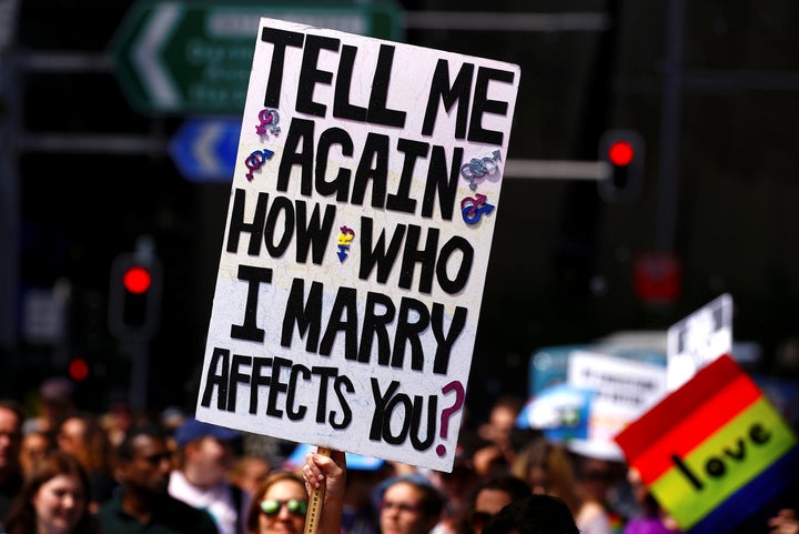 A marcher holds aloft a sign as they participate in a marriage equality march in central Sydney. 