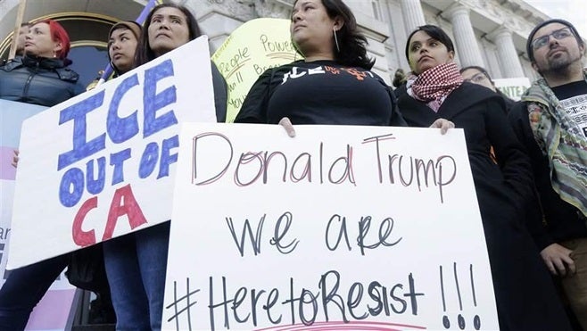 Protesters at a San Francisco rally opposing deportation of unauthorized immigrants. Gov. Jerry Brown, a Democrat, recently signed a law making California a sanctuary state.