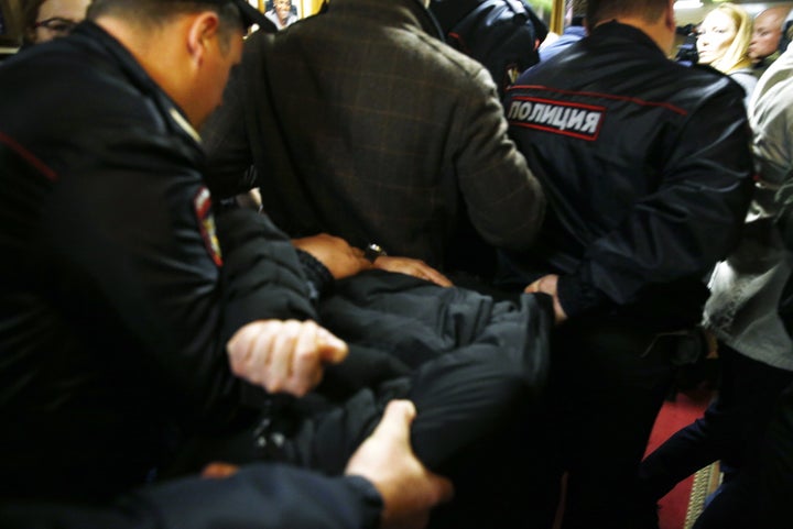 Police officers detain the man who attacked Tatyana Felgenhauer, a radio journalist at the Ekho Moskvy radio station in Moscow. 