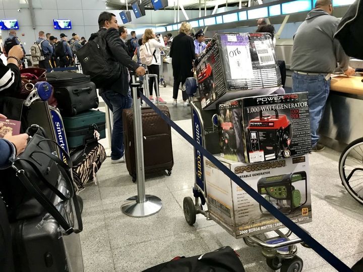 Travelers at JFK Airport in New York City prepare to check newly purchased generators as baggage for flights to San Juan Puerto Rico.