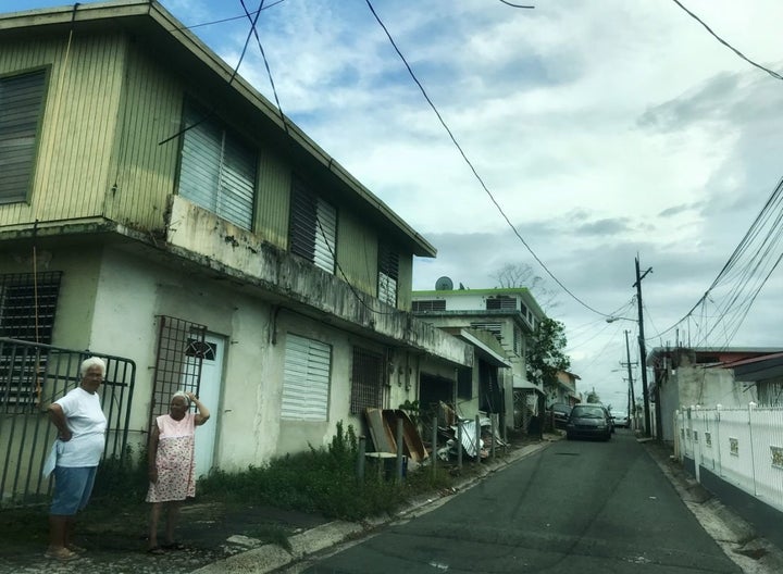 Two women stand on a residential street in Bayamon, Puerto Rico on Oct. 7, 2017 Nearly three weeks after Hurricane Maria stru