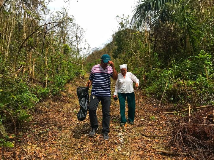 Jesse Vazquez and his mother, Mercedes Mercado, hike along a muddy path to their farm in Hatillo, Puerto Rico on Oct. 10, 2017 to survey the damage from Hurricane Maria.