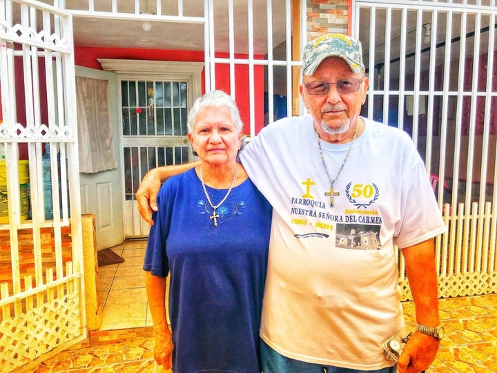 Ramona and Santos Lopez Caraballo stand outside their home in Arecibo, Puerto Rico on Oct. 10, 2017. The couple had no cell s
