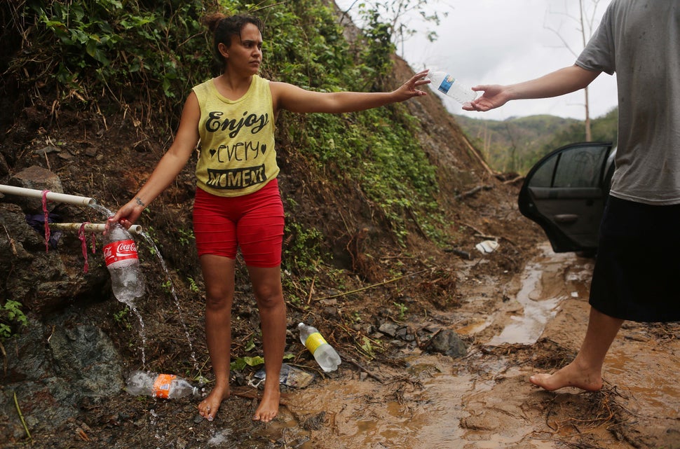 Yanira Rios collects spring water nearly three weeks after Hurricane Maria destroyed her town of Utuado. It's not clear if th
