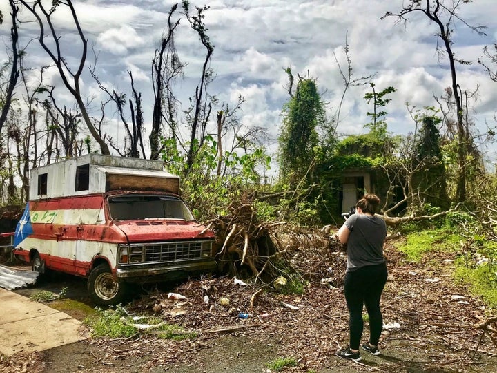 Megan Vazquez photographs the destruction around an abandoned van and hot dog stand near her hometown of Bayamon, Puerto Rico