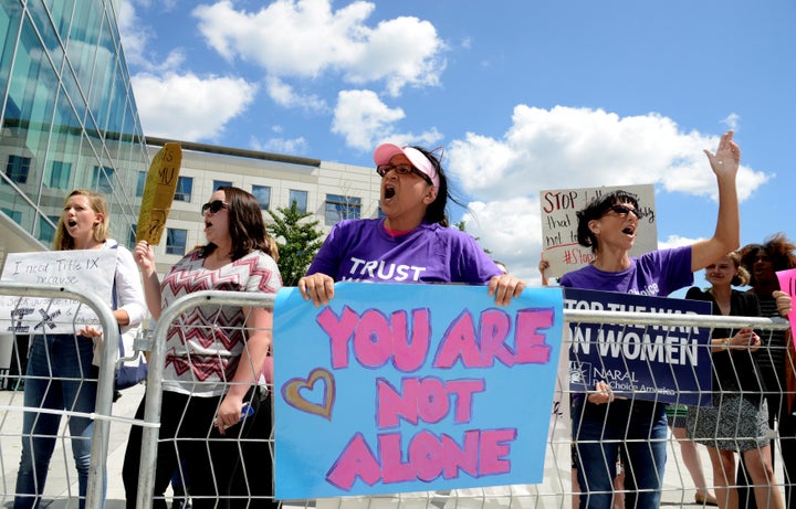 A group of demonstrators gather outside Founders Hall in Arlington, Virginia, where Education Secretary Betsy DeVos delivered