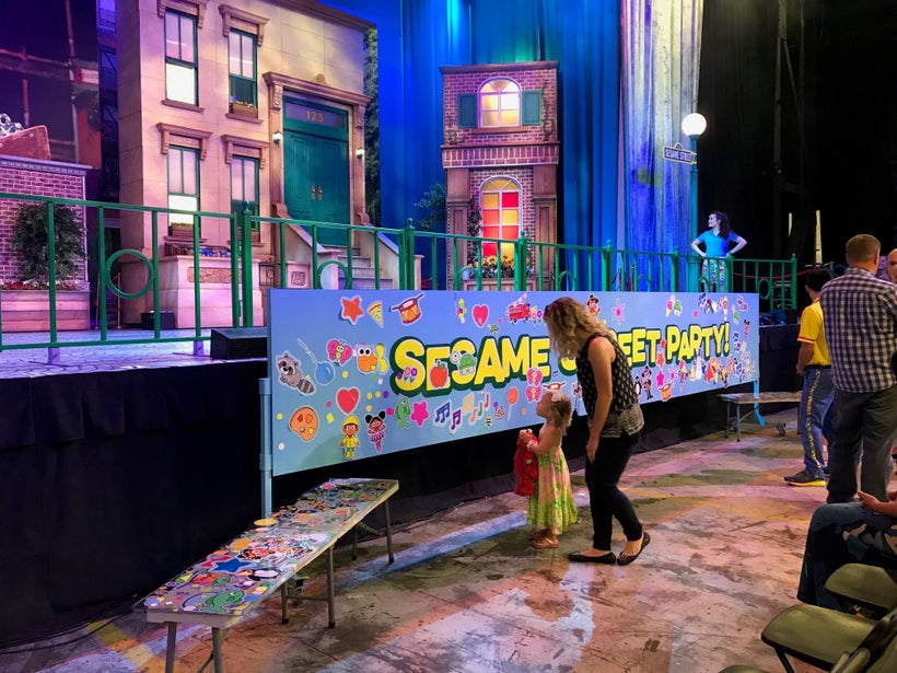 Children decorate a banner with stickers during the VIP Pre Show Experience