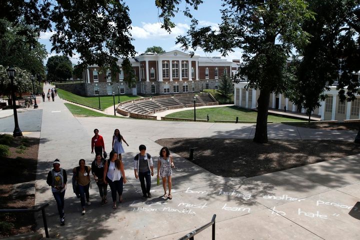 Students walks past a quote in chalk credited to Nelson Mandela at the University of Virginia a week after a white nationalist rally took place on campus.