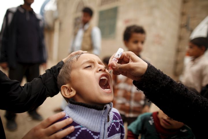 A boy receives polio vaccination drops during a house-to-house vaccination campaign in Yemen's capital, Sanaa, on April 10, 2016.